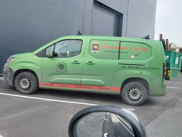 Grønn varebil fra "Malermester FAG AS" parkert utenfor en moderne bygning